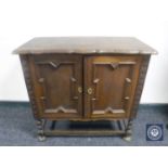 A twentieth century oak double door cabinet on bobbin legs