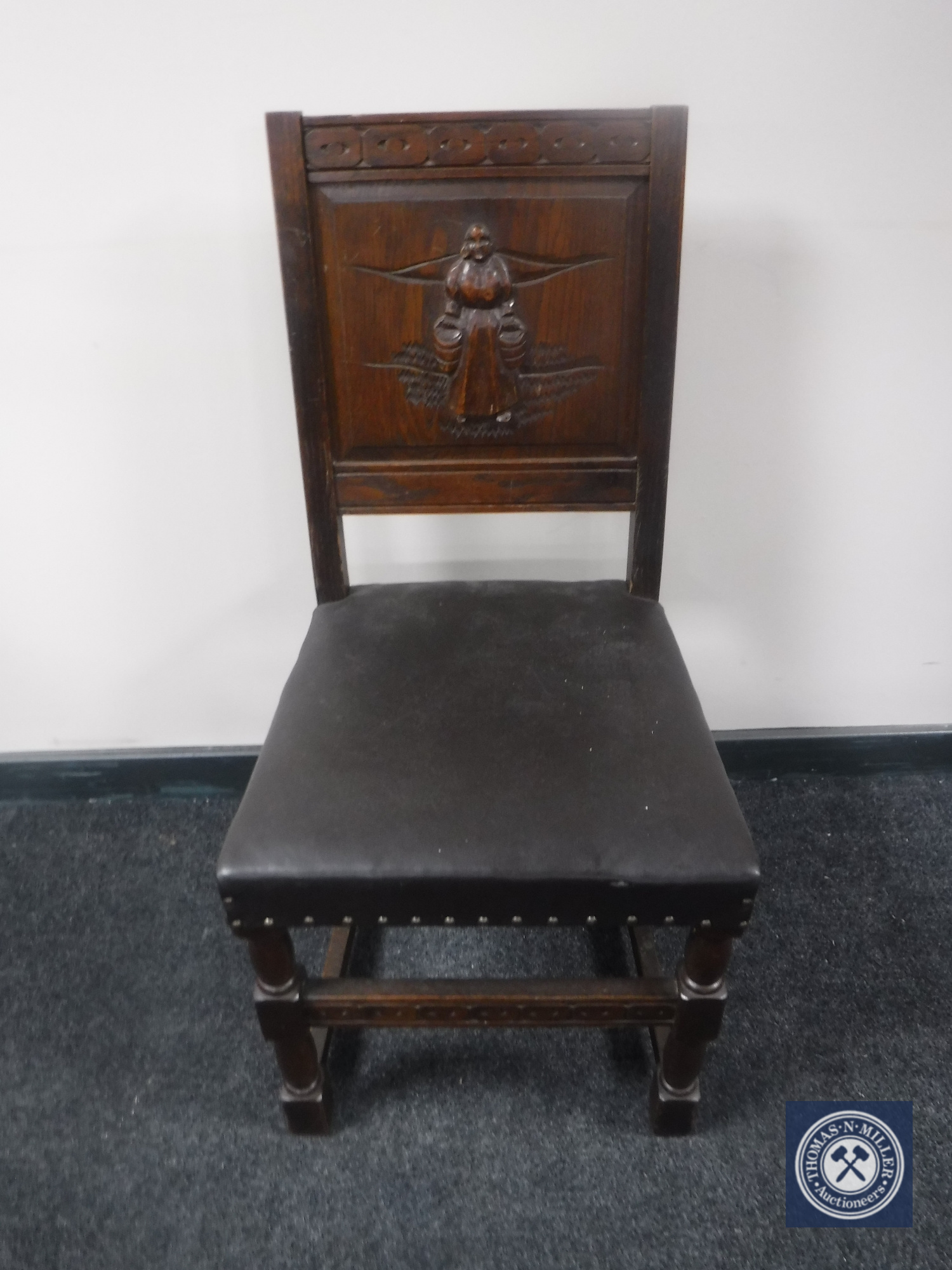 A carved oak panel back dining chair