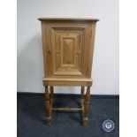 A blond oak cabinet on stand