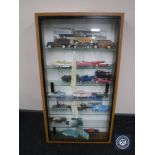 A sliding door display case containing a collection of die cast vehicles