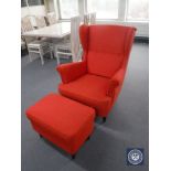 A contemporary button back wing armchair with stool in red fabric