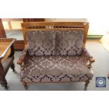 An antique inlaid walnut framed settee in purple brocade fabric