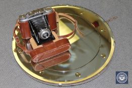 A porthole mirror together with an Agfa Isolette folding camera