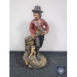 A painted wooden figure of a huntsman with dog