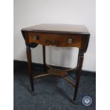 A mahogany flap sided occasional table on brass castors