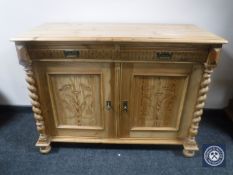 An early 20th century pine double door sideboard with barley twist pillar supports
