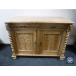 An early 20th century pine double door sideboard with barley twist pillar supports