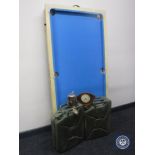 A folding pool table with accessories, two metal jerry cans,