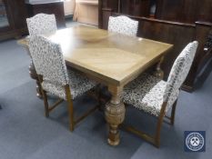 An early 20th century oak pull out table with four floral upholstered dining chairs