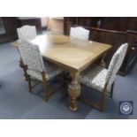 An early 20th century oak pull out table with four floral upholstered dining chairs