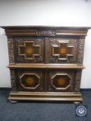 An early 20th century carved oak four door cabinet