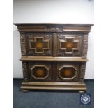 An early 20th century carved oak four door cabinet