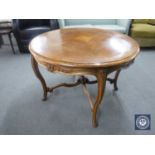 A circular walnut coffee table on cabriole legs