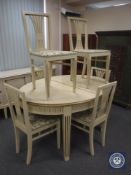 A white and gilt oval extending painted table with six chairs