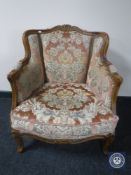 A twentieth century continental walnut framed armchair upholstered in a pink floral brocade