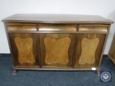 A continental mahogany serpentine fronted triple door sideboard