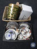 A wicker basket and box containing oriental style wall and cabinet plates,