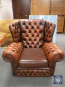 A brown buttoned leather Chesterfield wingback armchair