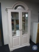 A contemporary washed pine double door display cabinet with domed top