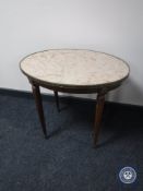 An oval mahogany marble topped occasional table with metal mounts