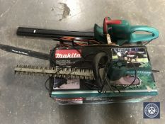 A Makita electric chain saw together with a Bosch electric hedge trimmer and one other hedge