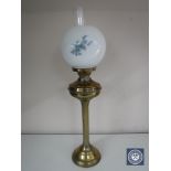 A brass oil lamp with glass shade and chimney