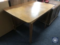 A mid twentieth century teak pull out dining table