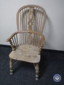 An antique elm kitchen armchair