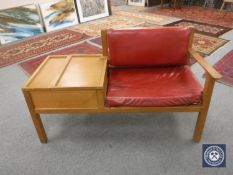 A mid twentieth century oak storage telephone table upholstered in red leather