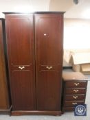 A mahogany effect double door wardrobe together with matching six drawer chest