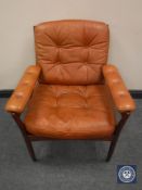 A Danish wooden framed armchair upholstered in tan buttoned leather