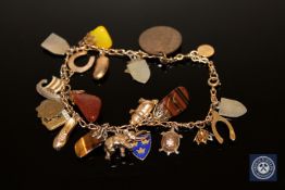 A gold charm bracelet set with gold and other charms