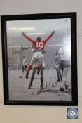 A monochrome photograph (with some red tinting) depicting Martin Peters and Geoff Hurst in