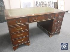 A 20th century mahogany twin pedestal writing desk with a green leather tooled panel