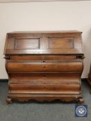 A 19th century oak bureau on bracket feet,