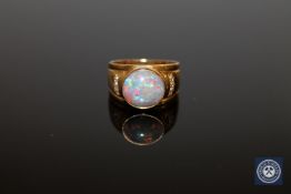 An 18ct gold opal and diamond ring, the oval cabochon white opal in a rubbed over setting,