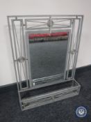 A metal framed mirror with shelf