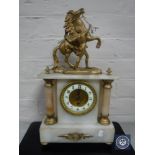 A gilt metal and alabaster mantel clock with enamel dial surmounted by a figure of a man with a