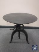 An industrial style circular metal adjustable bar table