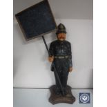 A wooden figure of a policeman with sign