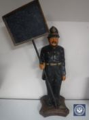 A wooden figure of a policeman with sign