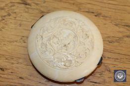 An antique carved ivory circular compact