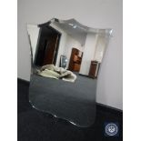 A frameless bevelled shield mirror