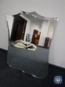A frameless bevelled shield mirror