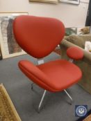 A contemporary abstract armchair upholstered in red vinyl on metal legs