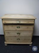 An antique pine four drawer chest on bun feet