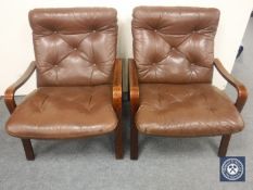 A pair of late twentieth century wooden framed armchairs upholstered in brown buttoned leather