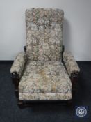 An oak framed tapestry upholstered reclining armchair