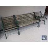 A wrought iron and wood three piece garden furniture set comprising bench and two armchairs