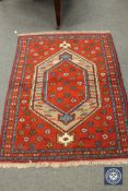 A Caucasian design rug on red ground,